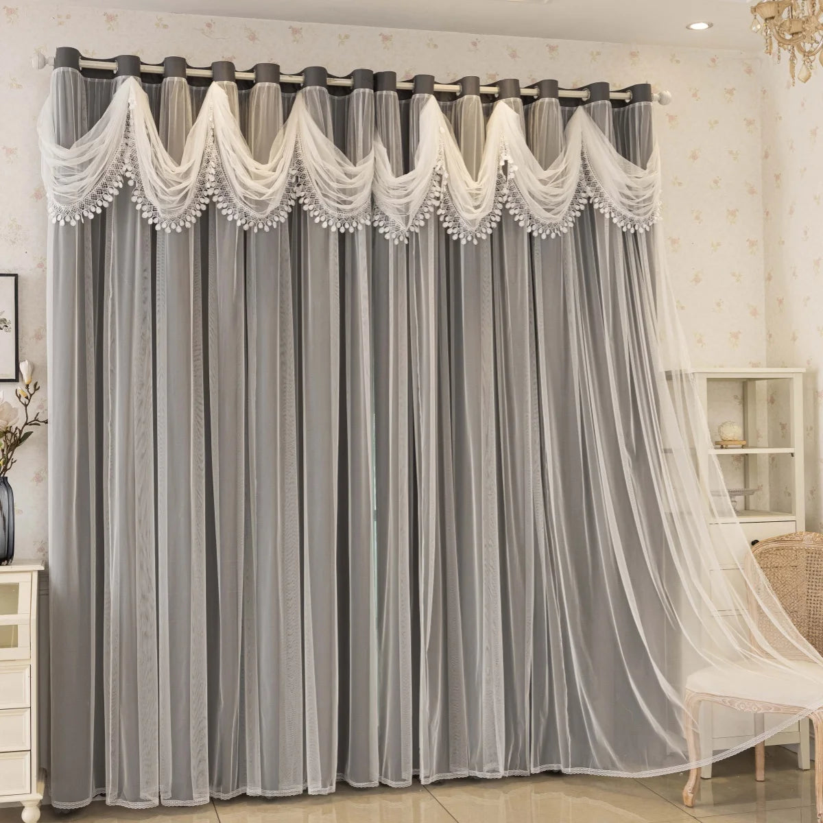 Gray sheer curtains with white wave pattern detail hanging in a window.