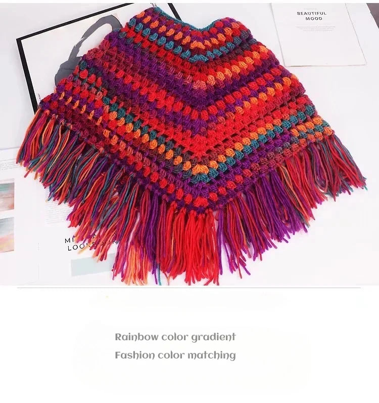 A hand-knitted poncho made from rainbow color gradient wool yarn with fringed edges.