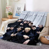 A group of young men in black clothing are posing together on a gray blanket with birthday text.