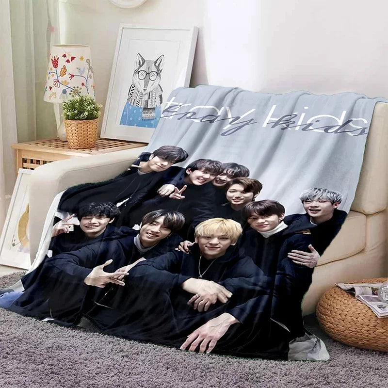 A group of young men in black clothing are posing together on a gray blanket with birthday text.