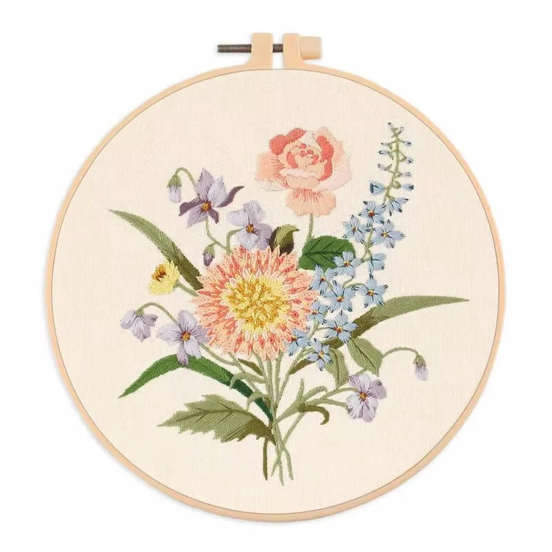 A beginner embroidery kit featuring floral patterns on a circular canvas with a wooden hanger.
