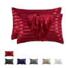 A set of red satin and striped pillow covers, including a decorative draped pillow and several solid colored pillows.