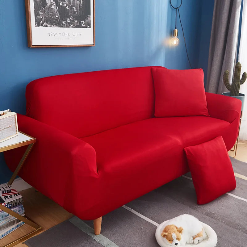 A vibrant red universal stretch sofa and chair slipcover displayed in a modern living room setting.