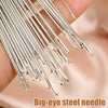 A hand holds a bundle of silver big-eye steel sewing needles.