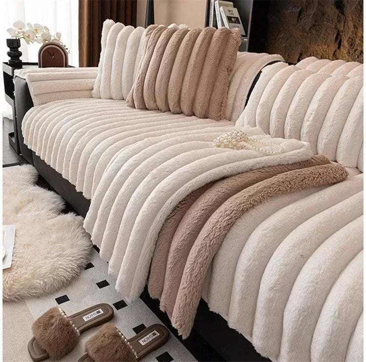 A beige plush sofa seat cushion with vertical pleats and a fluffy trim is shown on a dark sofa.