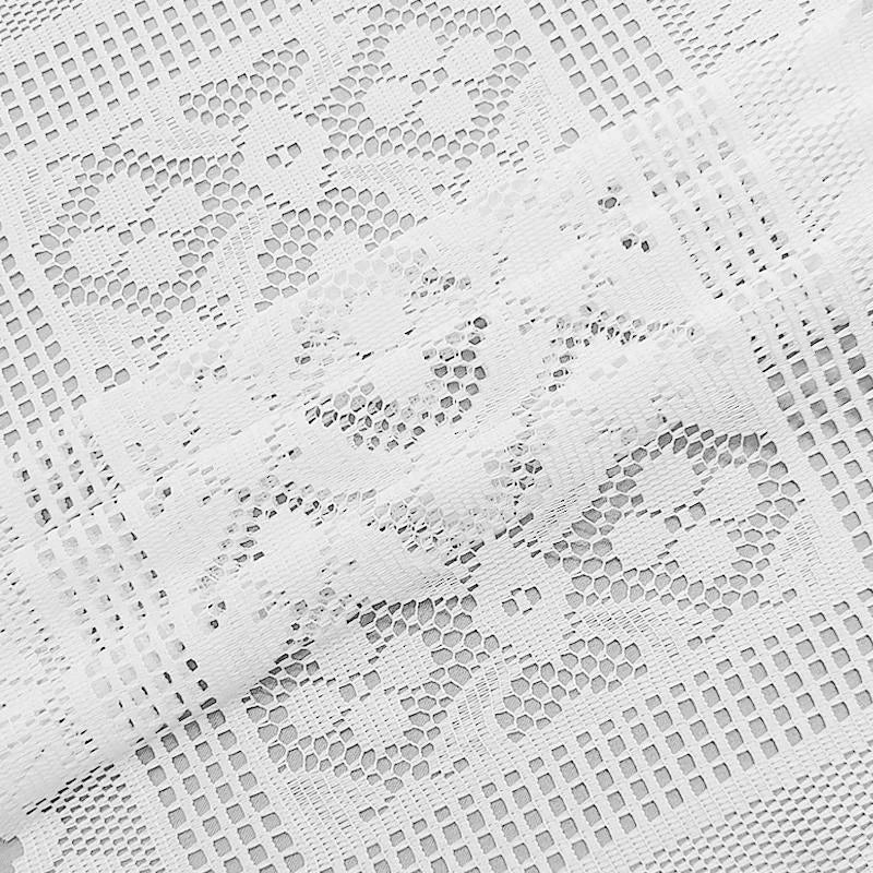 White lace table runner featuring a delicate, patterned design.