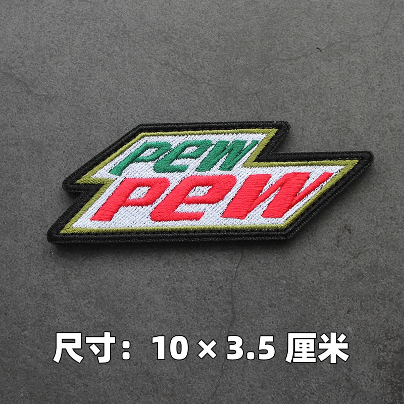 A embroidered patch featuring the text PEW in green and red on a black background.