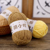 A close-up of several skeins of brown and yellow matte chenille yarn with Chinese characters on the labels.
