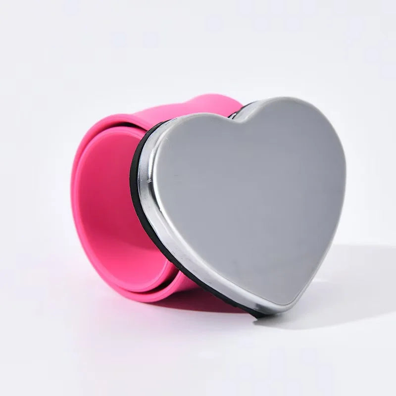 A pink magnetic wrist pincushion with a silver heart-shaped silicone band.