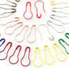 A collection of colorful safety bulb pins for knitting and sewing, including various shapes and colors.