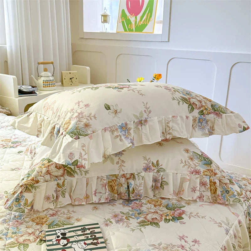 A floral cotton pillow cover set featuring pink and green botanical patterns on a white background.