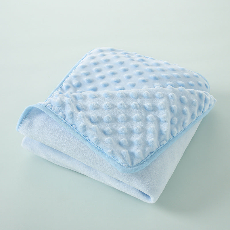Light blue fleece swaddle blanket with a quilted texture folded on a light gray surface.