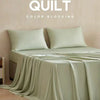 A light sage green quilt blocking fabric draped over a bed, with text reading QUILT COLOR BLOCKING.