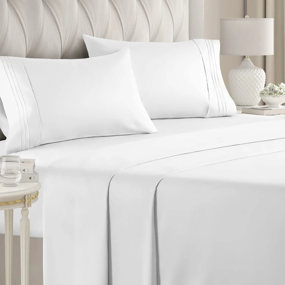 White luxury microfiber bed sheet set with deep pockets and decorative piping on a bed.