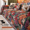 A richly colored floral jacquard sofa throw blanket featuring deep reds, oranges, purples, and greens.
