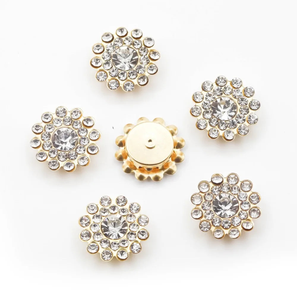 A collection of gold-toned sew-on rhinestone crystals in various flower shapes and sizes.