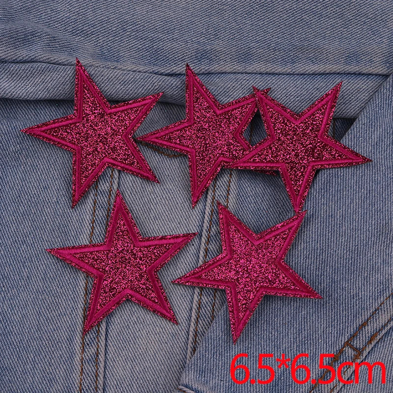 Five pink glitter star patches embroidered on a denim fabric.