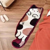 A rectangular plush rug shaped like a cartoon cat in white and brown colors resting on a wooden floor.