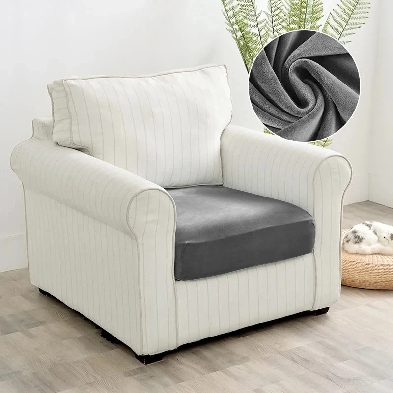 A cream upholstered armchair with a gray seat cover and vertical stripes sits on a light wood floor.