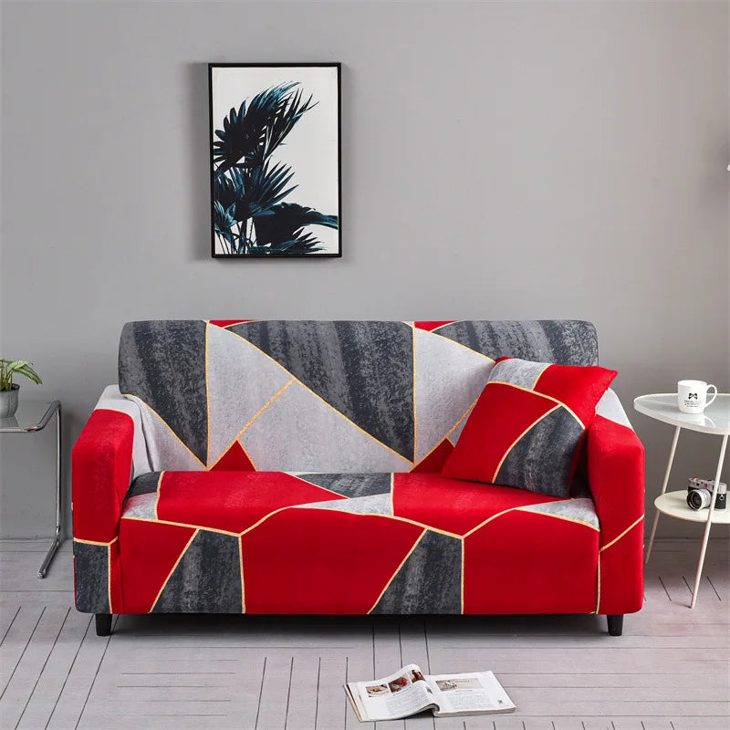 A red and black geometric patterned elastic sofa cover protector displayed in a modern living room.