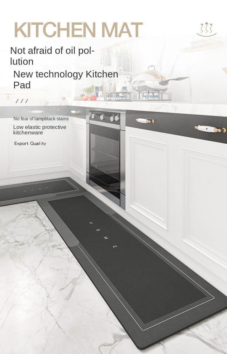 A black kitchen mat is shown placed on a marble floor in front of white cabinets and appliances.