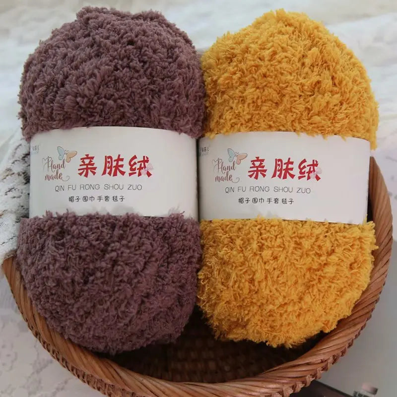 Two skeins of soft coral velvet yarn in purple and yellow are displayed in a wooden bowl.