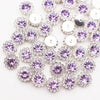 Silver and purple crystal rhinestone sew-on buttons arranged in a floral pattern