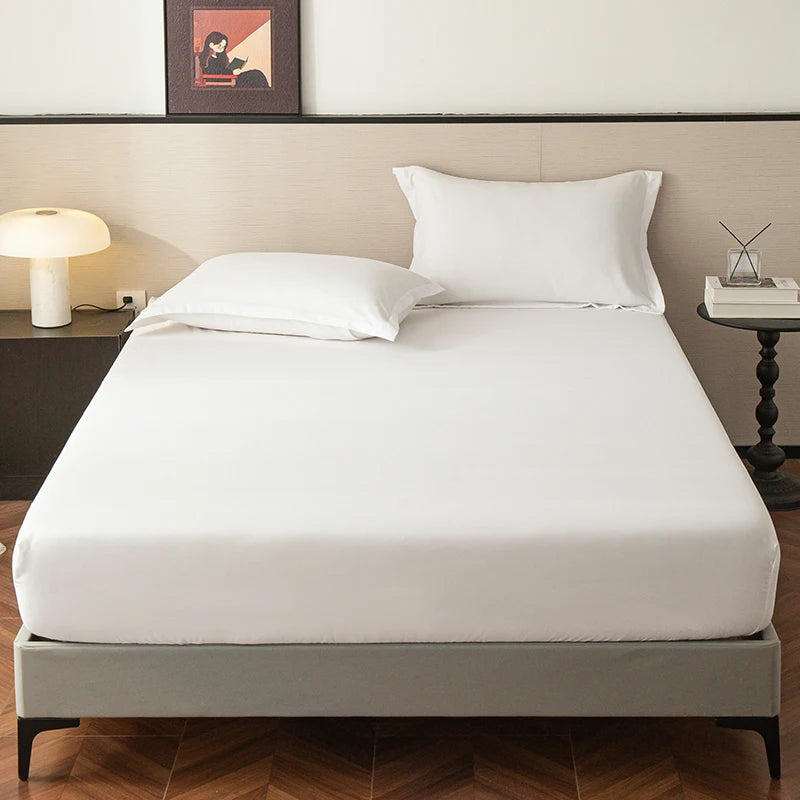 A clean white fitted sheet is laid on a bed, displayed in a modern bedroom setting.