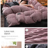 A set of ultra-soft corduroy duvet covers in dusty rose and charcoal colors shown on a bed.