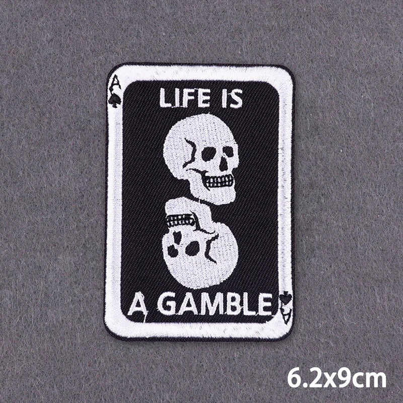 A black and white embroidered patch featuring a skull and the text Life is a gamble.