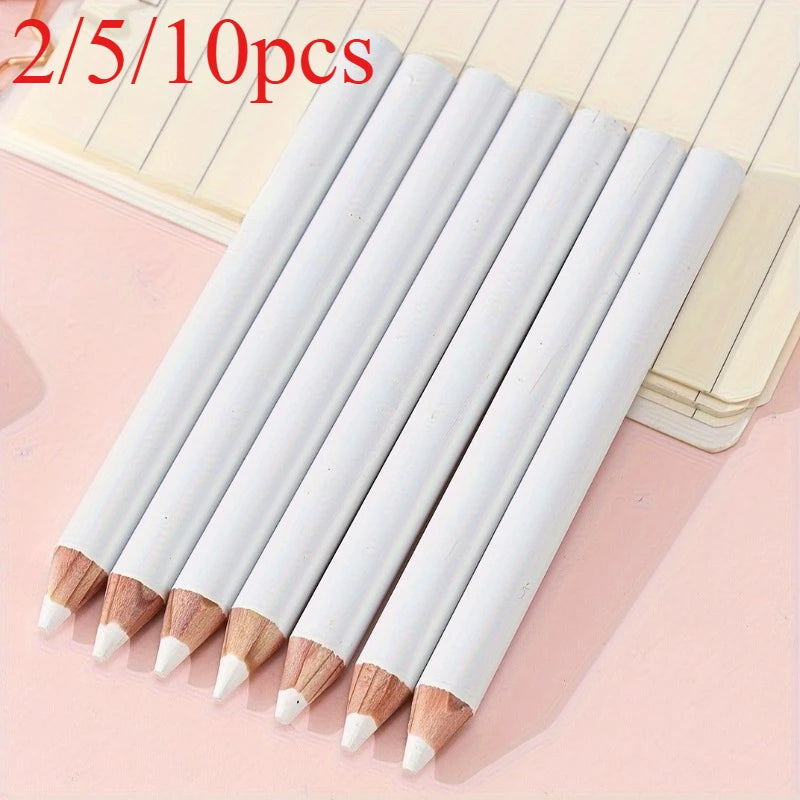 A set of ten white and natural wood bamboo chalk pencils laid diagonally on a light pink surface.