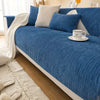 A deep blue geometric chenille sofa cushion cover with light gray accent pillows and a white throw blanket.
