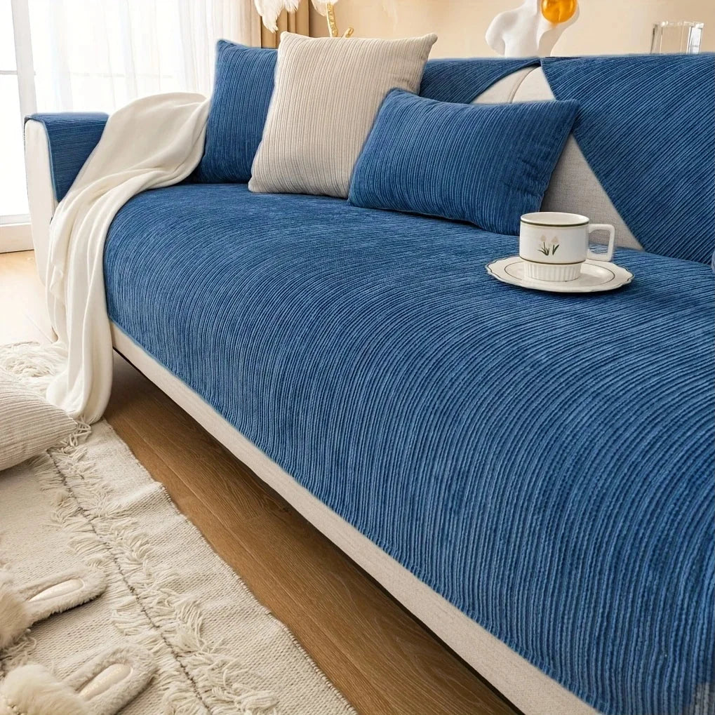 A deep blue geometric chenille sofa cushion cover with light gray accent pillows and a white throw blanket.