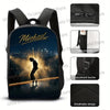 Black backpack featuring a silhouette of a person standing on a road with bright lights against a city skyline.