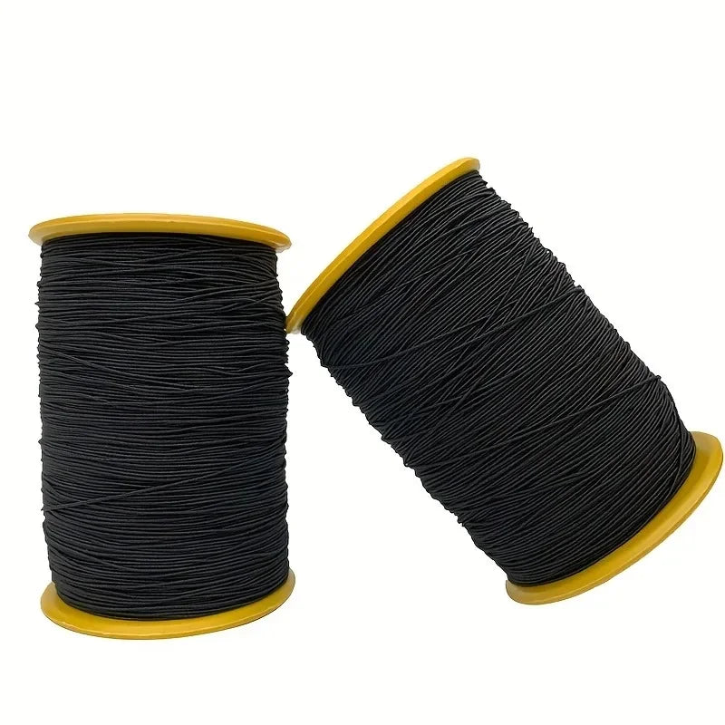 Spool of black elastic sewing thread with a yellow cap