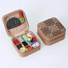 A brown storage box containing a retro style zipper sewing kit with various needles and tools.