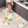A set of two diamond print non-slip waterproof kitchen rugs displayed on a light wood floor next to dark cabinets.