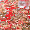 Close-up of red and beige bohemian printed linen fabric with floral patterns on a table.