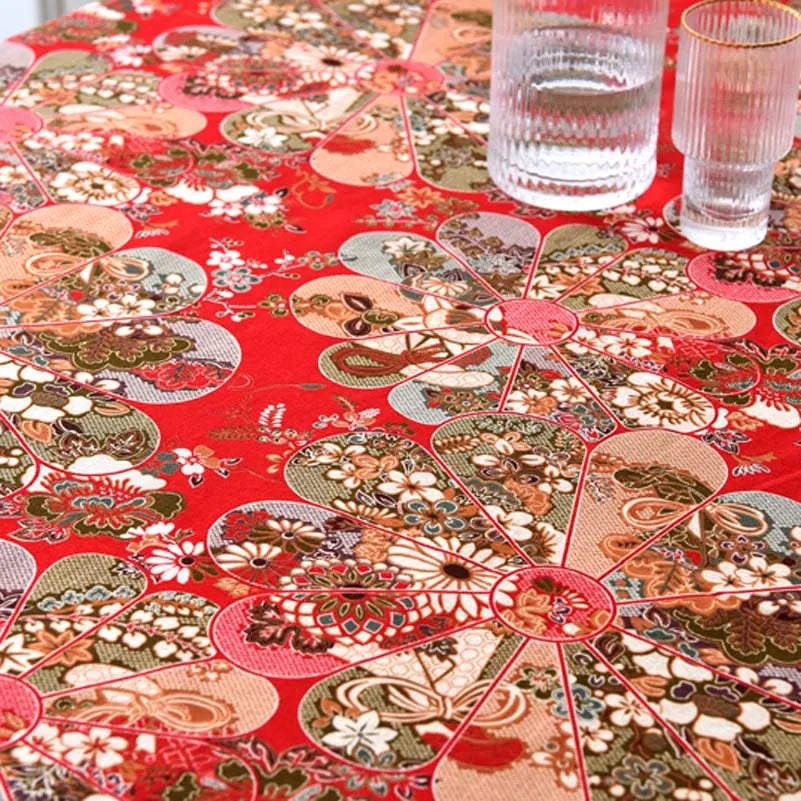 Close-up of red and beige bohemian printed linen fabric with floral patterns on a table.