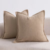 A close-up of a beige textured boucle throw pillow resting on a light-colored sofa.
