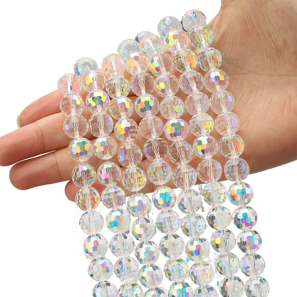 A hand holds a strand of multi-size shiny AB crystal glass beads for jewelry making