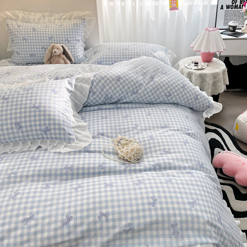 A light blue and white gingham duvet cover set with floral bowknot accents displayed on a bed.