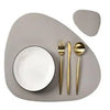 A set of reusable vinyl placemats and silverware displayed on a light gray plate.
