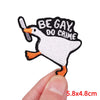 An embroidered patch of a white duck with black text that reads BE GAY DO CRIME