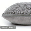 A close-up view of a gray faux fur throw pillow cover with visible zipper details.
