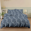 A navy blue botanical print duvet cover set featuring silvery-white foliage and branches on a bed.