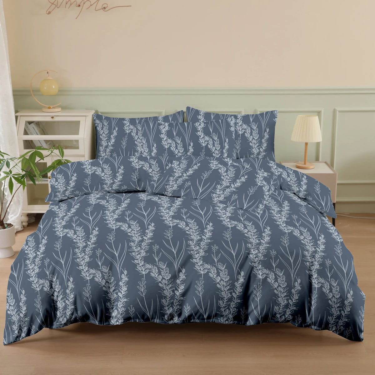 A navy blue botanical print duvet cover set featuring silvery-white foliage and branches on a bed.