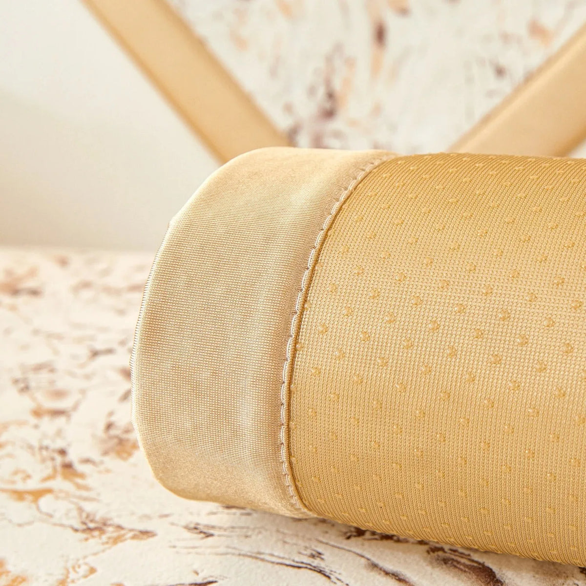 A close-up of a beige velvet sofa cushion cover with gold foil detailing.