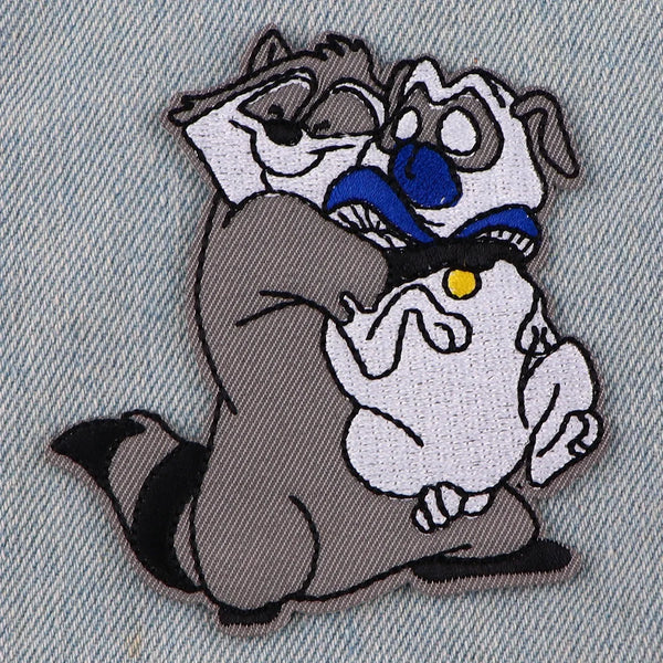 An embroidered patch featuring a stylized dog hugging another dog.