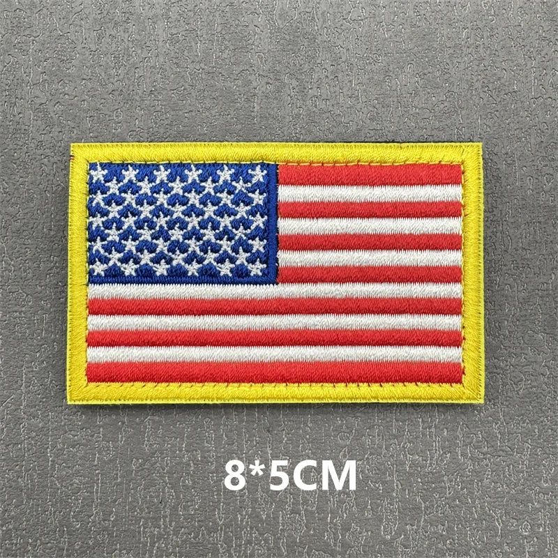 A rectangular USA flag patch with stars and stripes on a yellow fabric background.